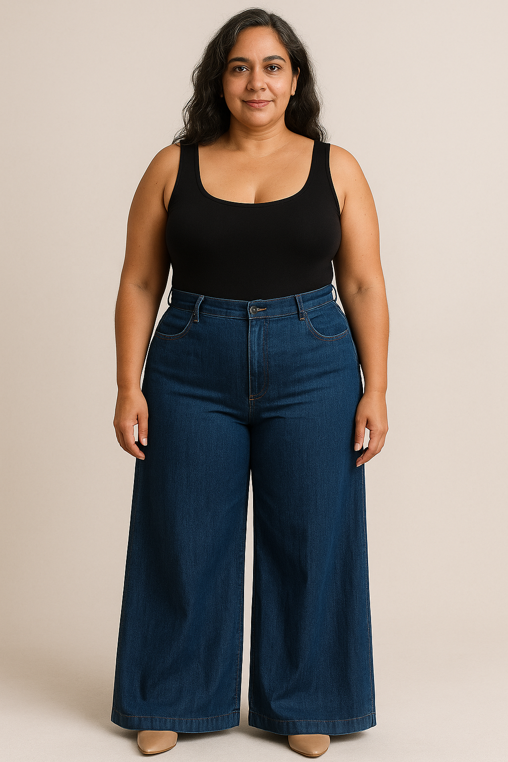 Plus-size woman in high-waisted denim palazzo pants and a fitted black bodysuit, styled to flatter pear and hourglass figures.