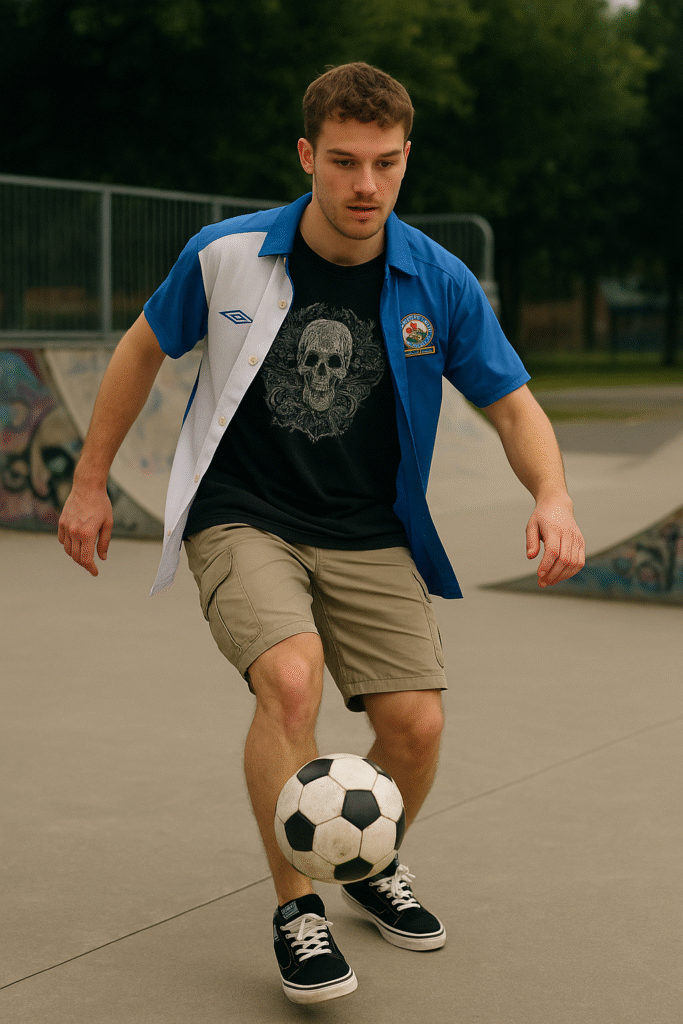 Young man playing football in a skate park wearing a Blackburn Rovers jersey over a graphic tee, cargo shorts, and Vans Half-Cabs—perfect example of Y2K football fashion and blokecore style.